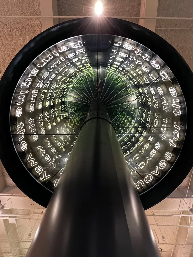 The infinity mirror at the upper landing, looking up through the helix.